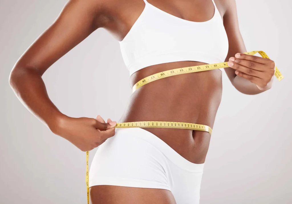 Woman with perfect body shape with measuring tape after Weight Loss Program