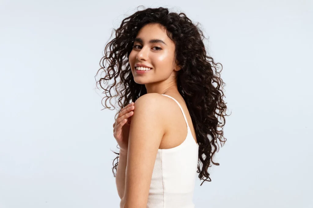 Girl with beautiful skin and curly hair after personalised skin treatment in San Mateo
