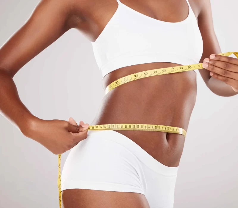 Woman with perfect body shape with measuring tape after Weight Loss Program